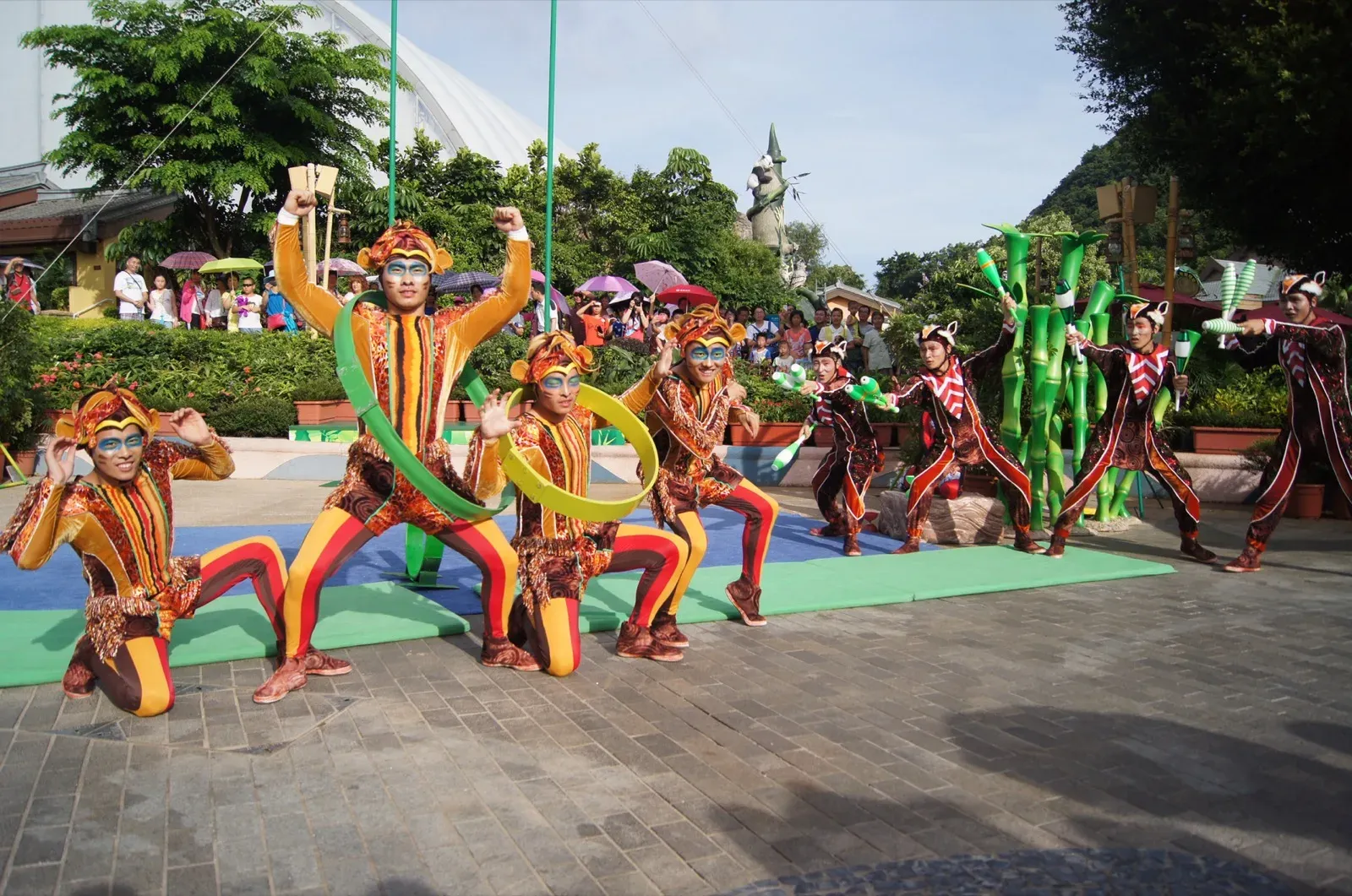 Bamboo Jam circus troupe with hoops and bamboo props on an outdoor theme park stage in Hong Kong