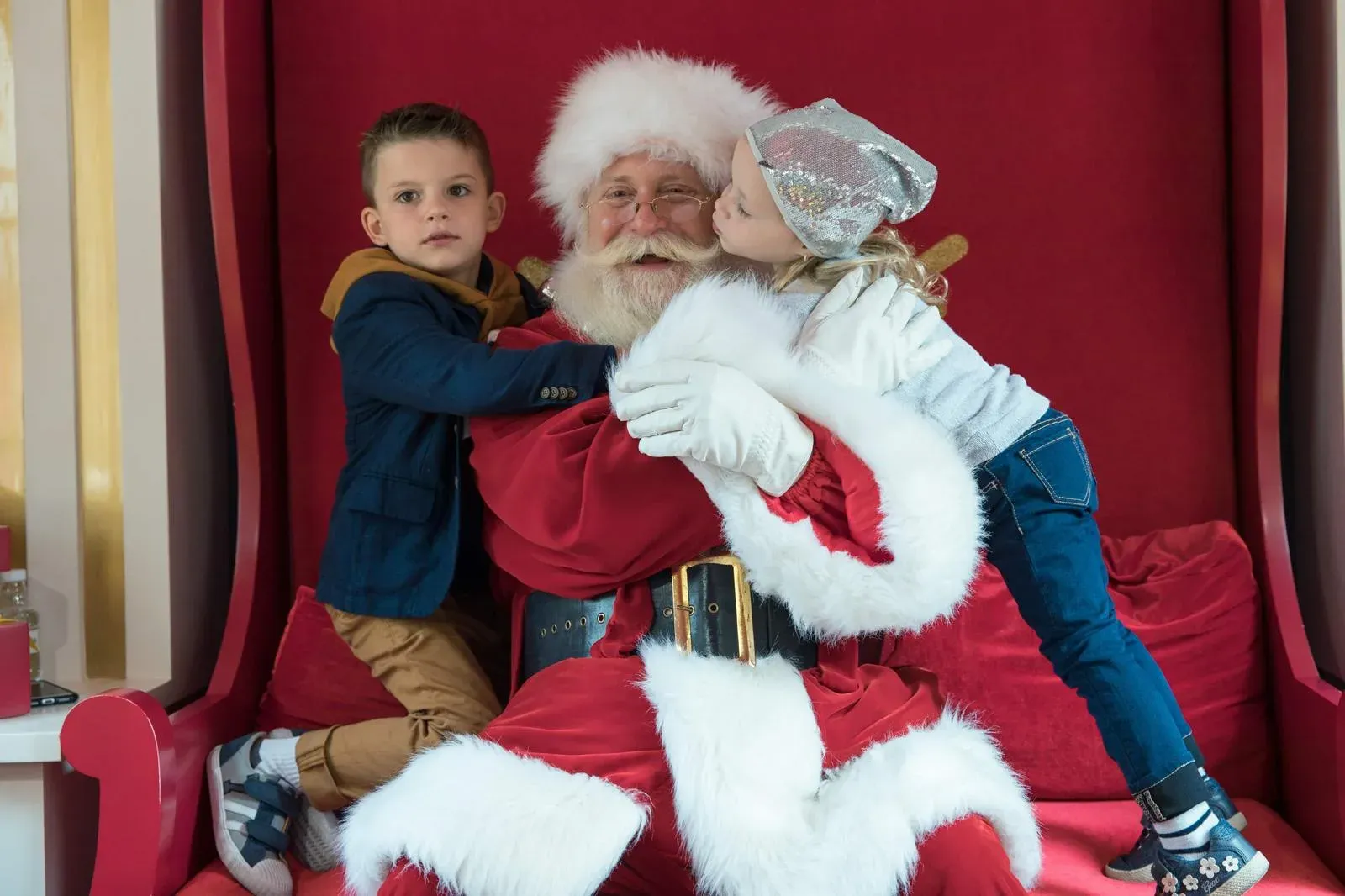 Western Santa hugging two children on his red throne in Hong Kong