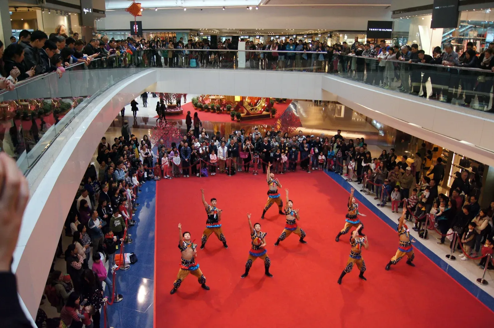 Kung fu team in a synchronised routine watched by shoppers on three floors of Festival Walk, Hong Kong