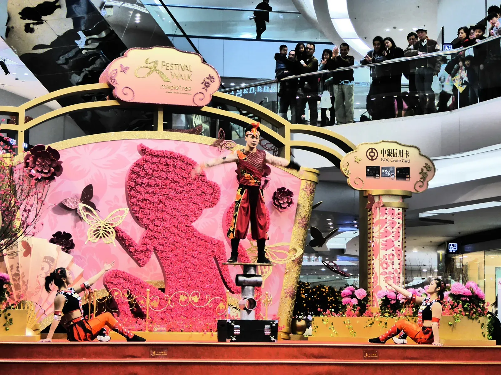 Chinese acrobats performing on the pink Chinese New Year stage at Festival Walk shopping mall, Hong Kong