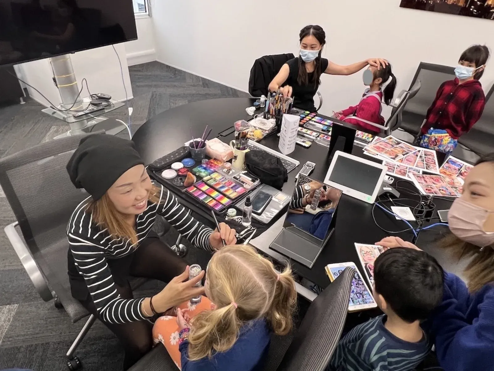 Face painters making up children at a Christmas office party in Hong Kong