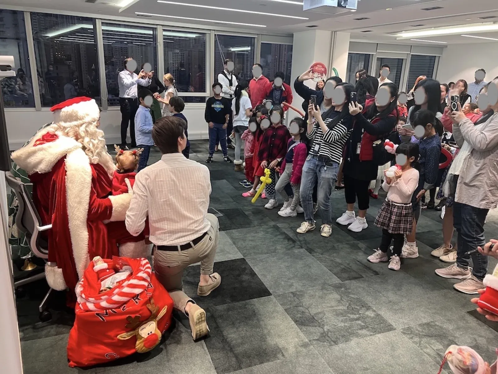 Santa handing out presents to children at a Christmas family day in a Hong Kong office