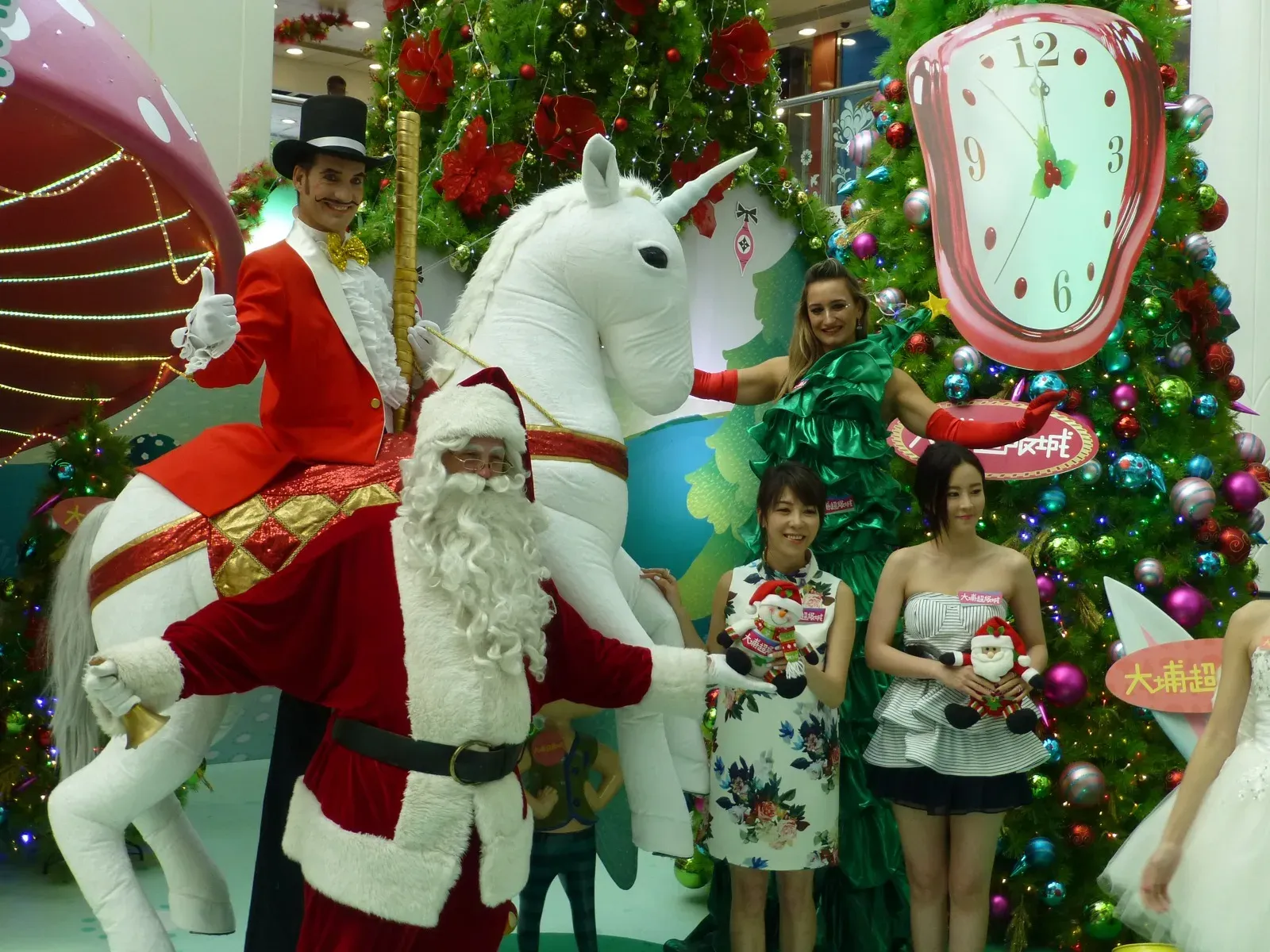 Santa and a white unicorn float in a Christmas parade through a Hong Kong shopping mall