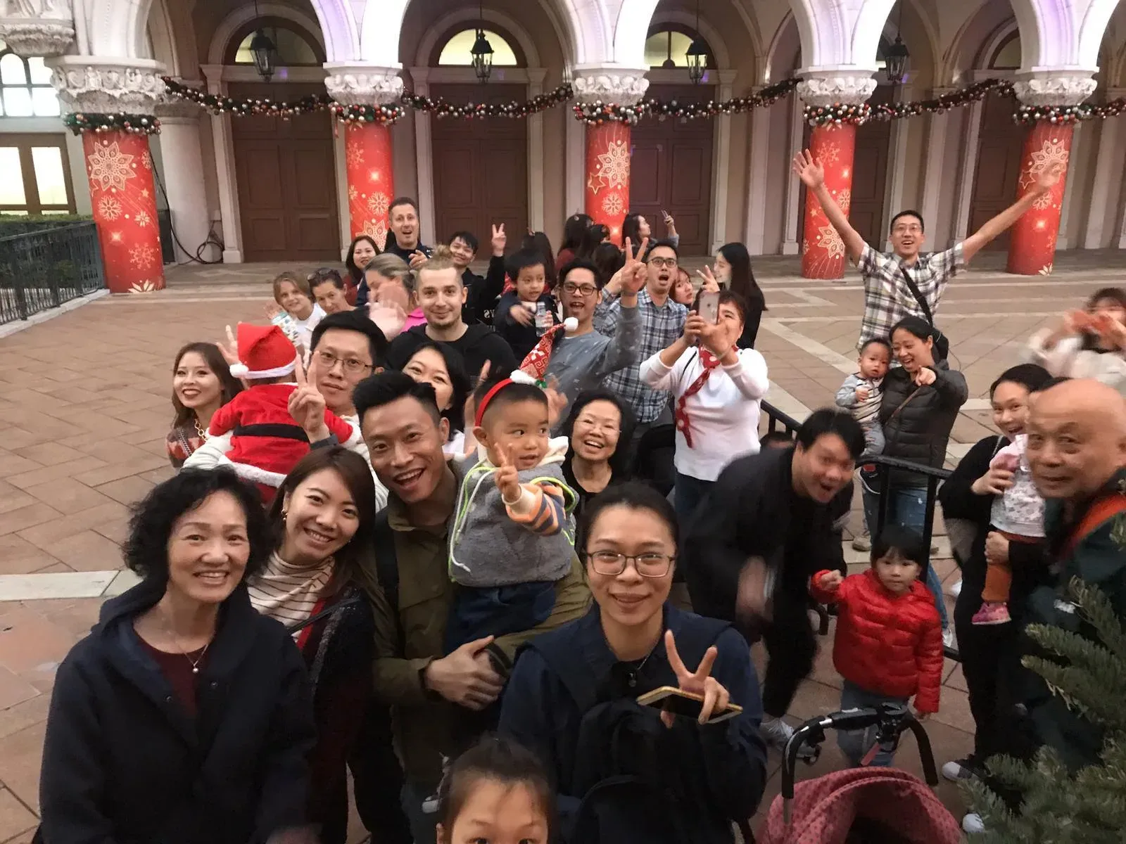 Festive crowd taking a group selfie in a decorated plaza