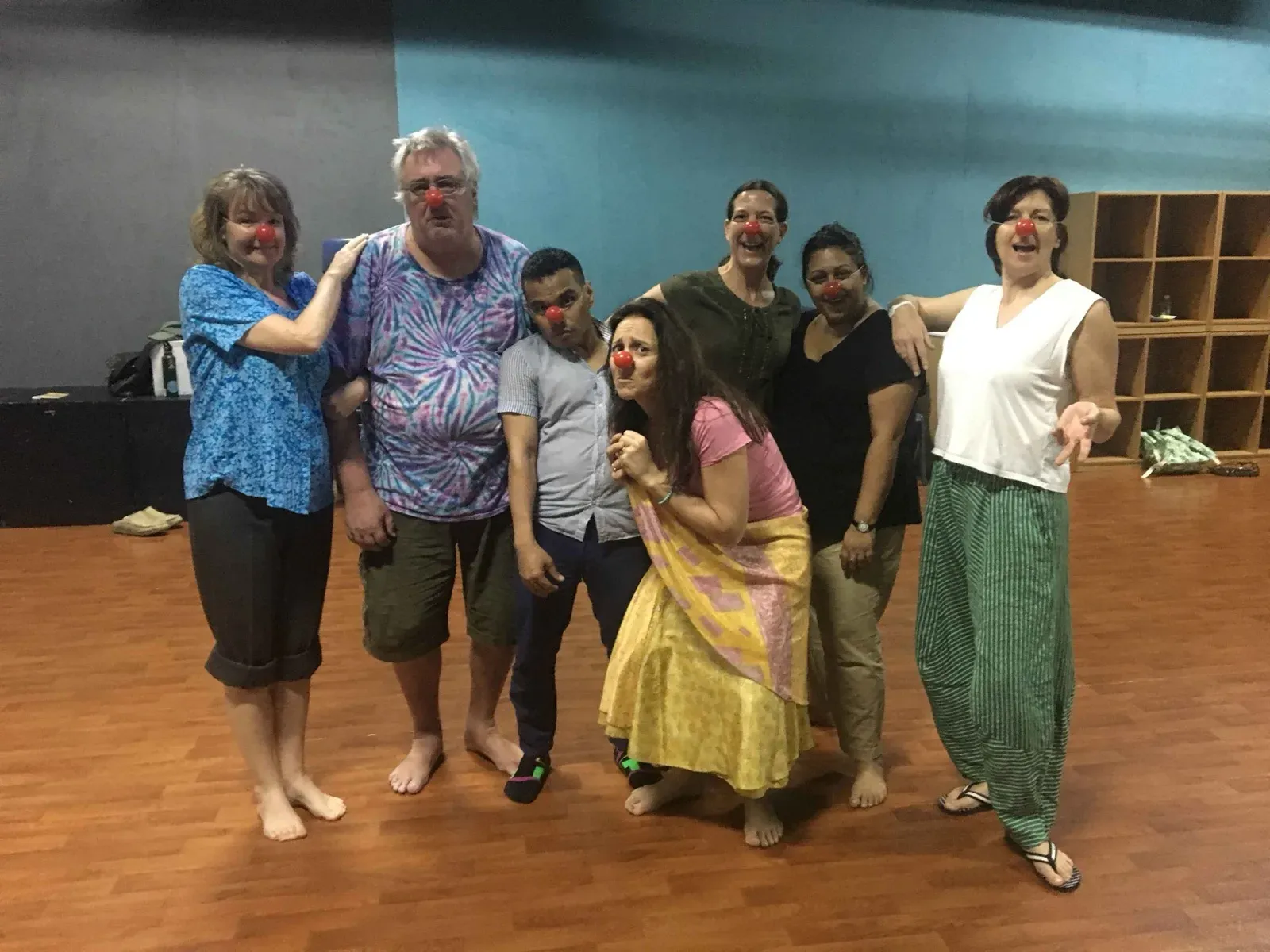 Clown workshop participants with red noses posing in a studio in Hong Kong