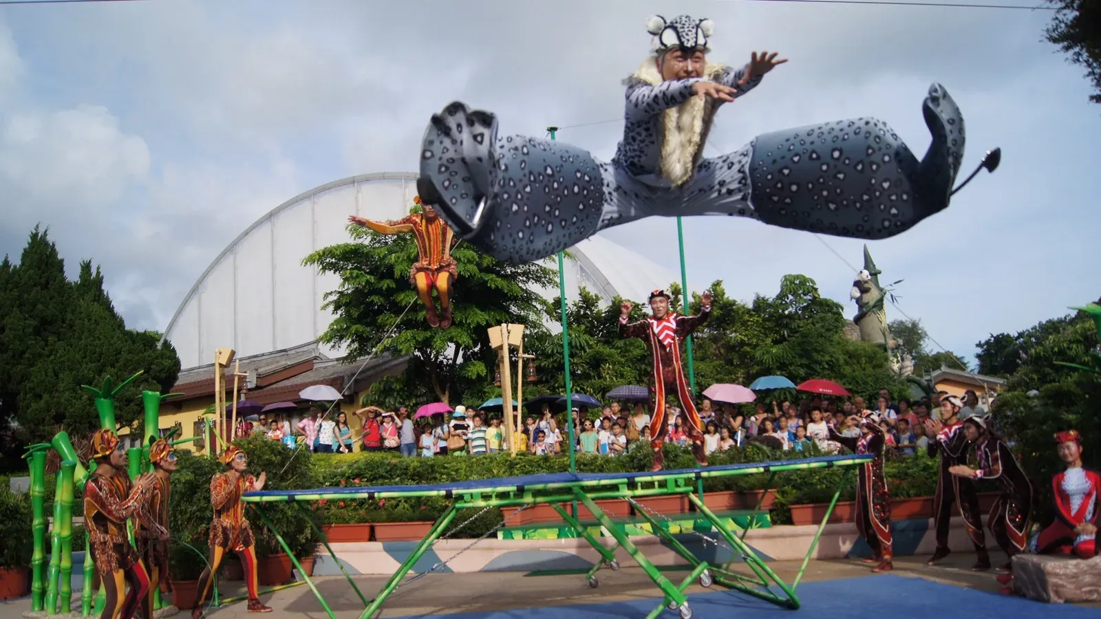 Circus acrobat flying from a teeterboard at an outdoor theme park show in Hong Kong