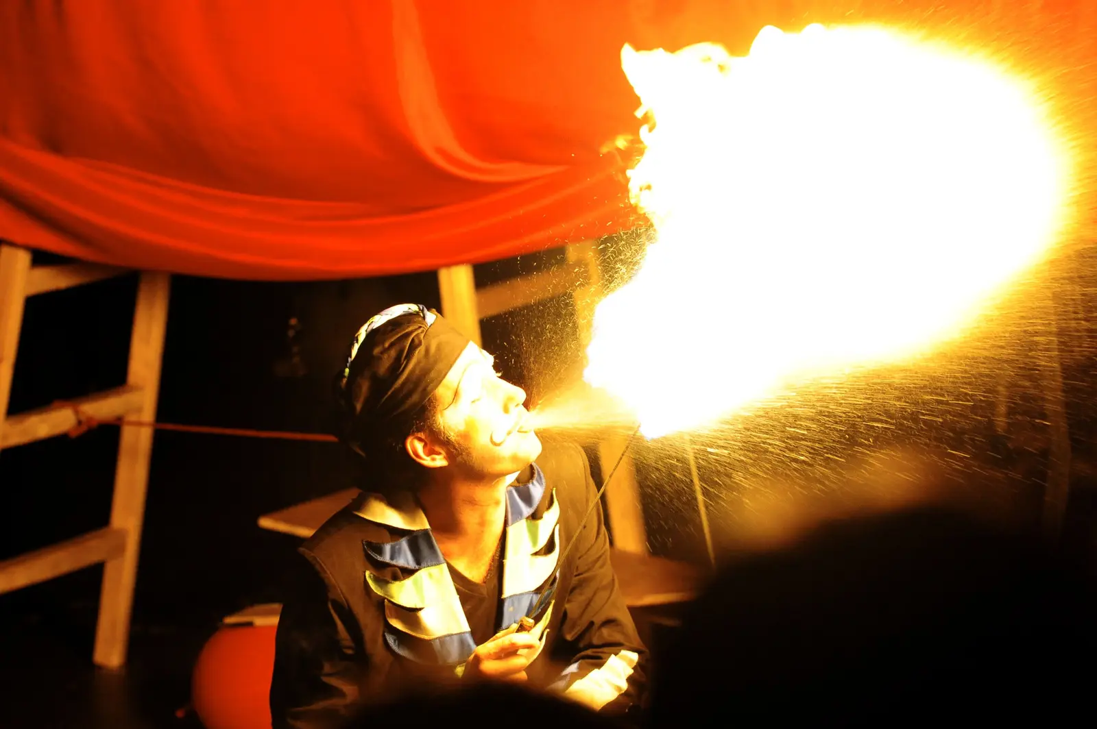 Performer blowing a flame at a fire show for an event in Hong Kong