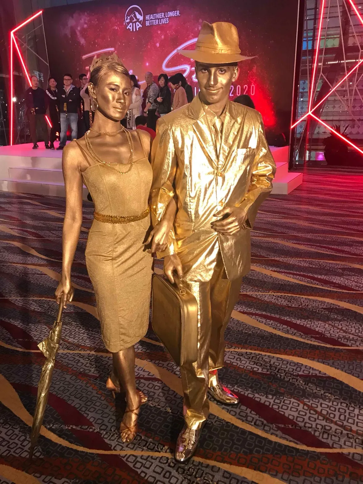 Two golden statue mimes in 1920s costumes at a Hong Kong event