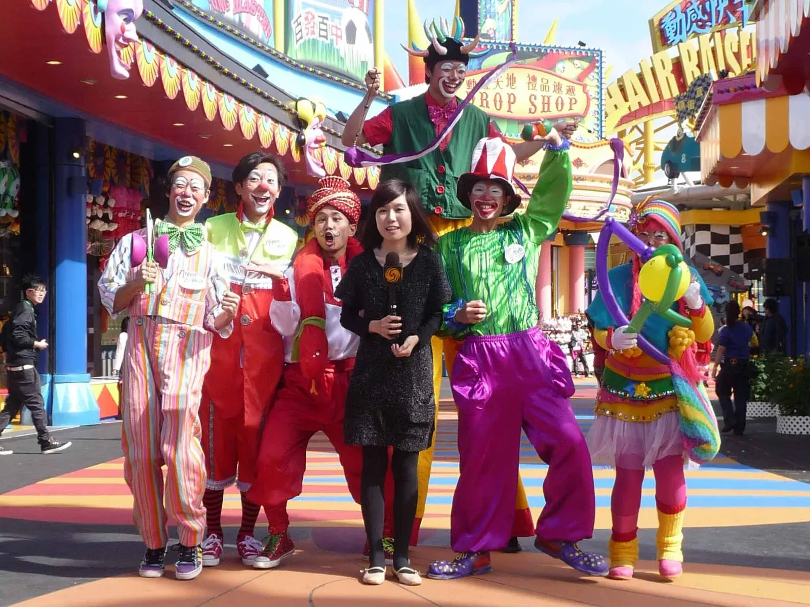 Team of colourful clowns and performers posing at a theme park in Hong Kong