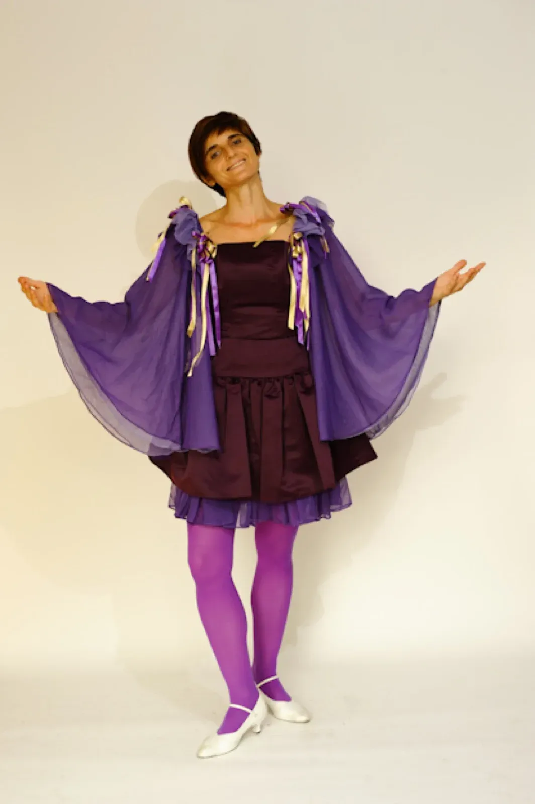 Dancer in a dark purple dress with wide purple sleeves