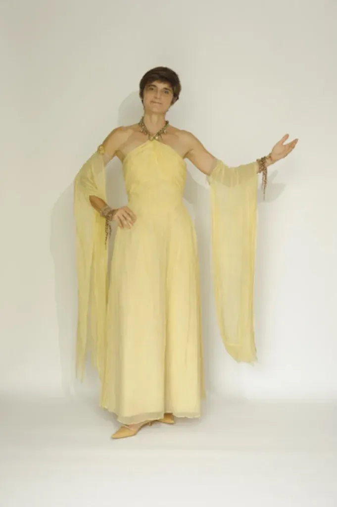 Performer in an elegant beige gown with long draped sleeves