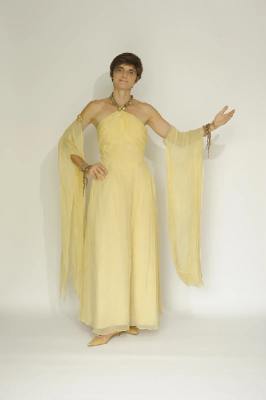 Performer in an elegant beige gown with long draped sleeves