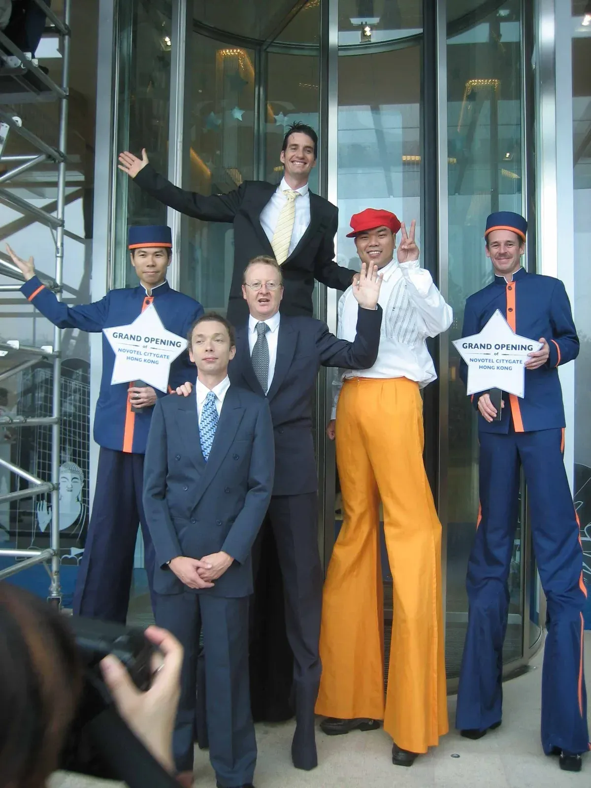 Stilts walkers and hotel staff in uniform posing at a Hong Kong hotel opening