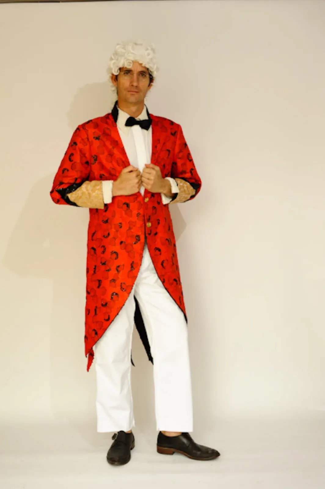 Male performer in a red coat and white trousers