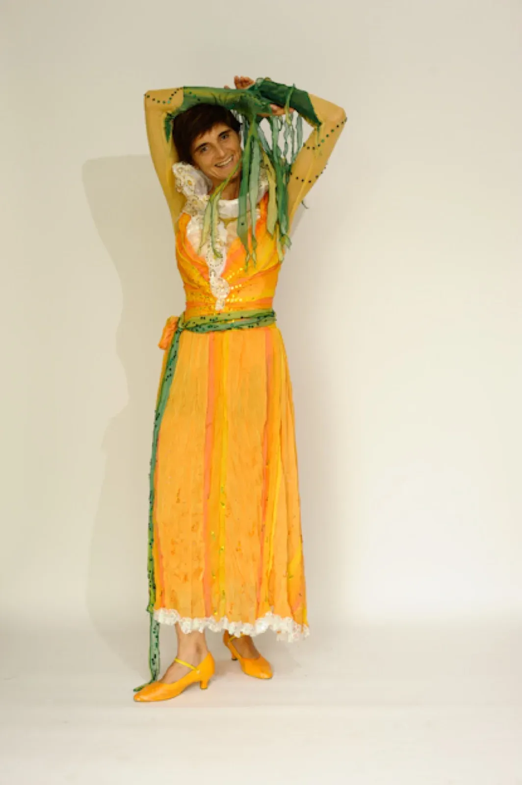 Performer in a long yellow dress with green sleeves