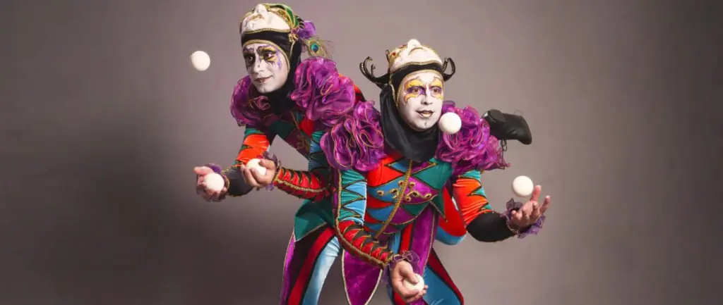 Two jugglers in bright costumes tossing white balls for events in Hong Kong and Macau
