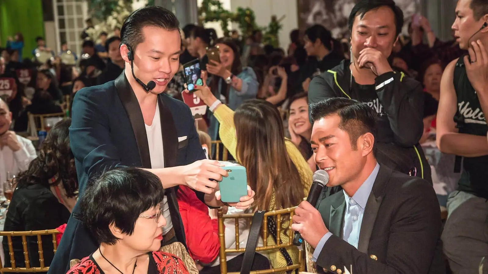 Close-up magician performing with cards for guests at a formal dinner