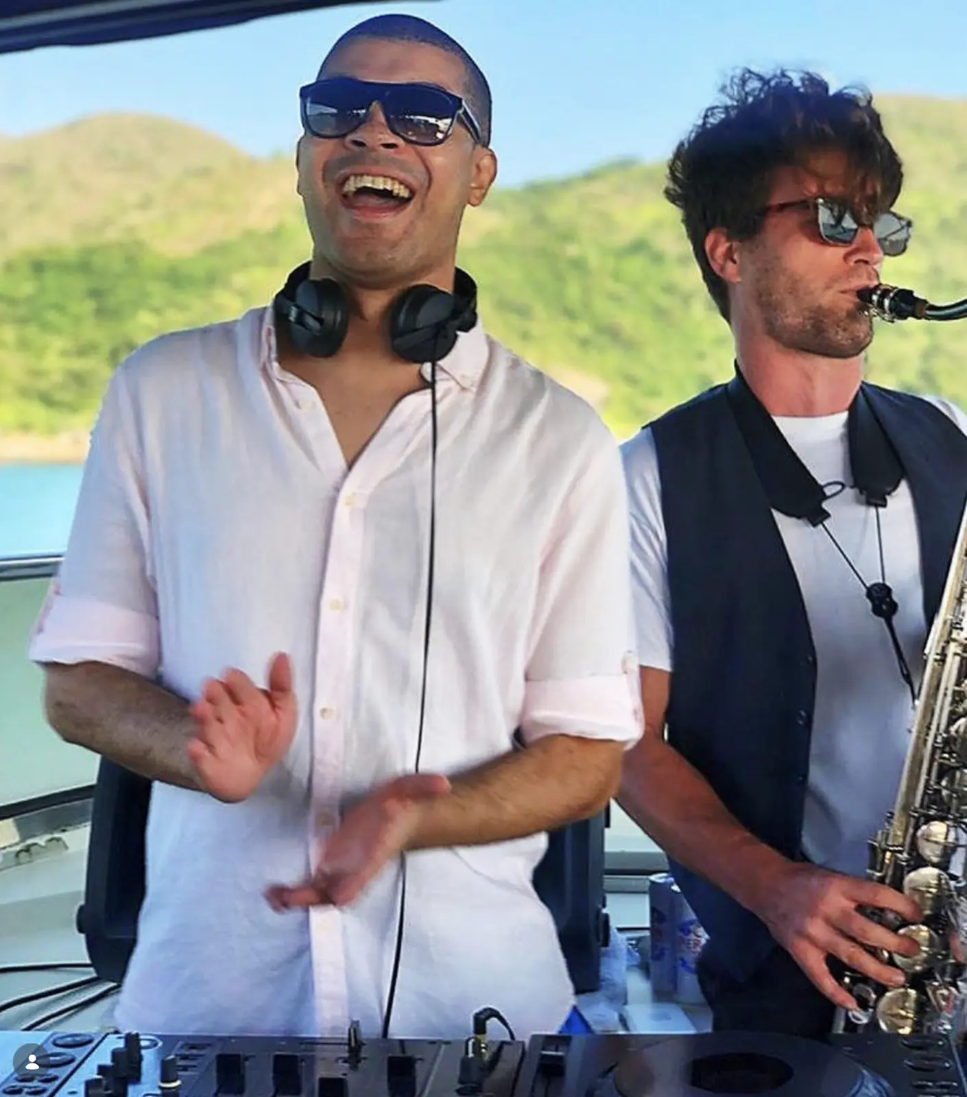 A DJ at the decks beside a musician playing saxophone at an event in Hong Kong