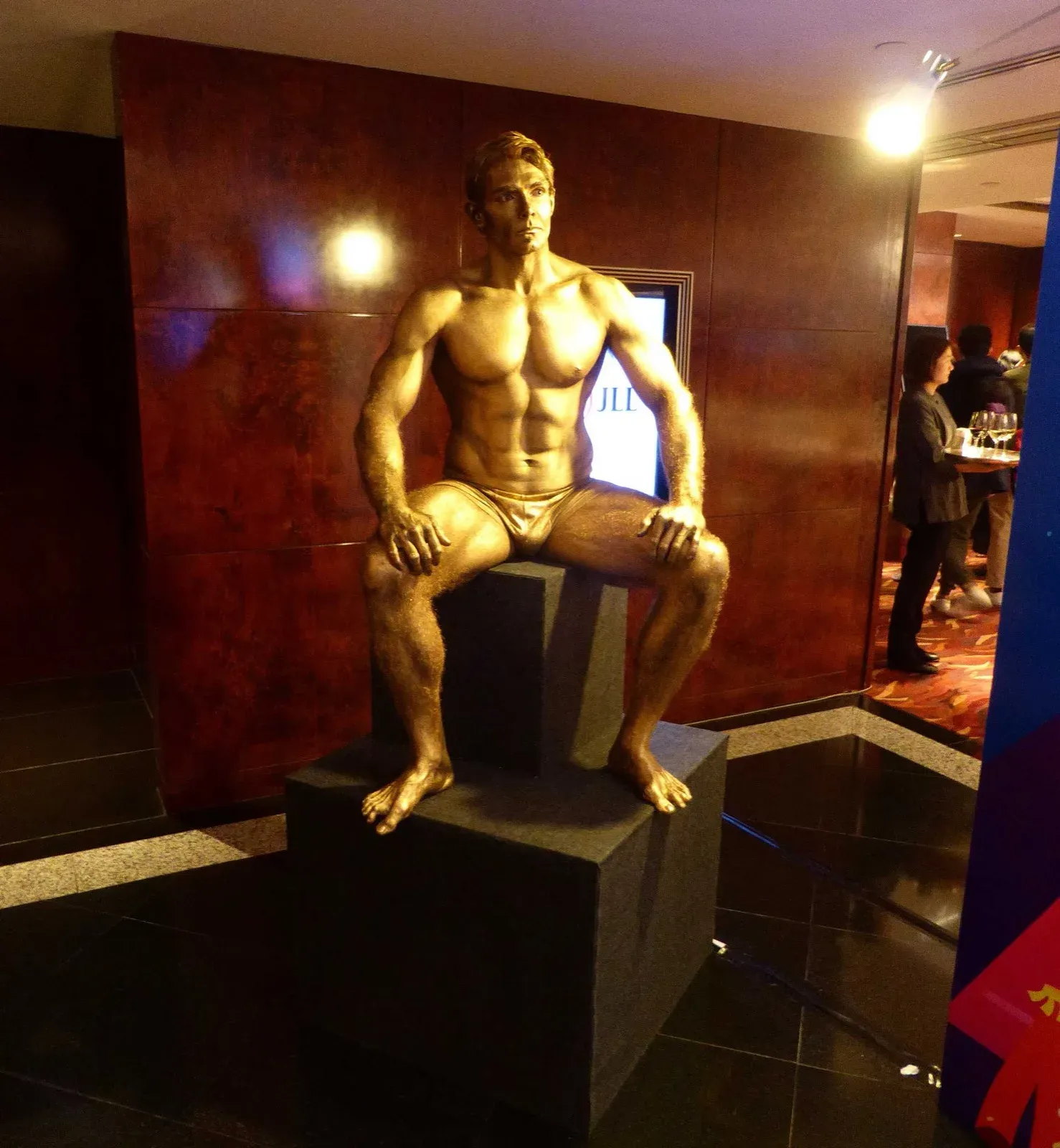 Gold-painted performer posing as Rodin's Thinker