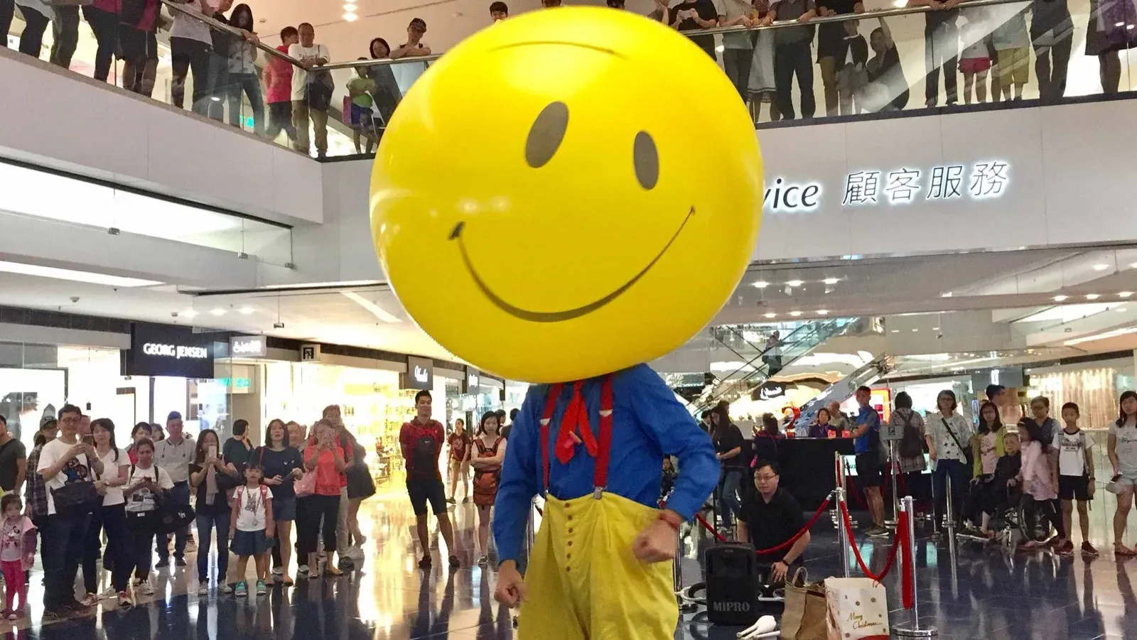 performer wears a smiley face balloon in Hong Kong