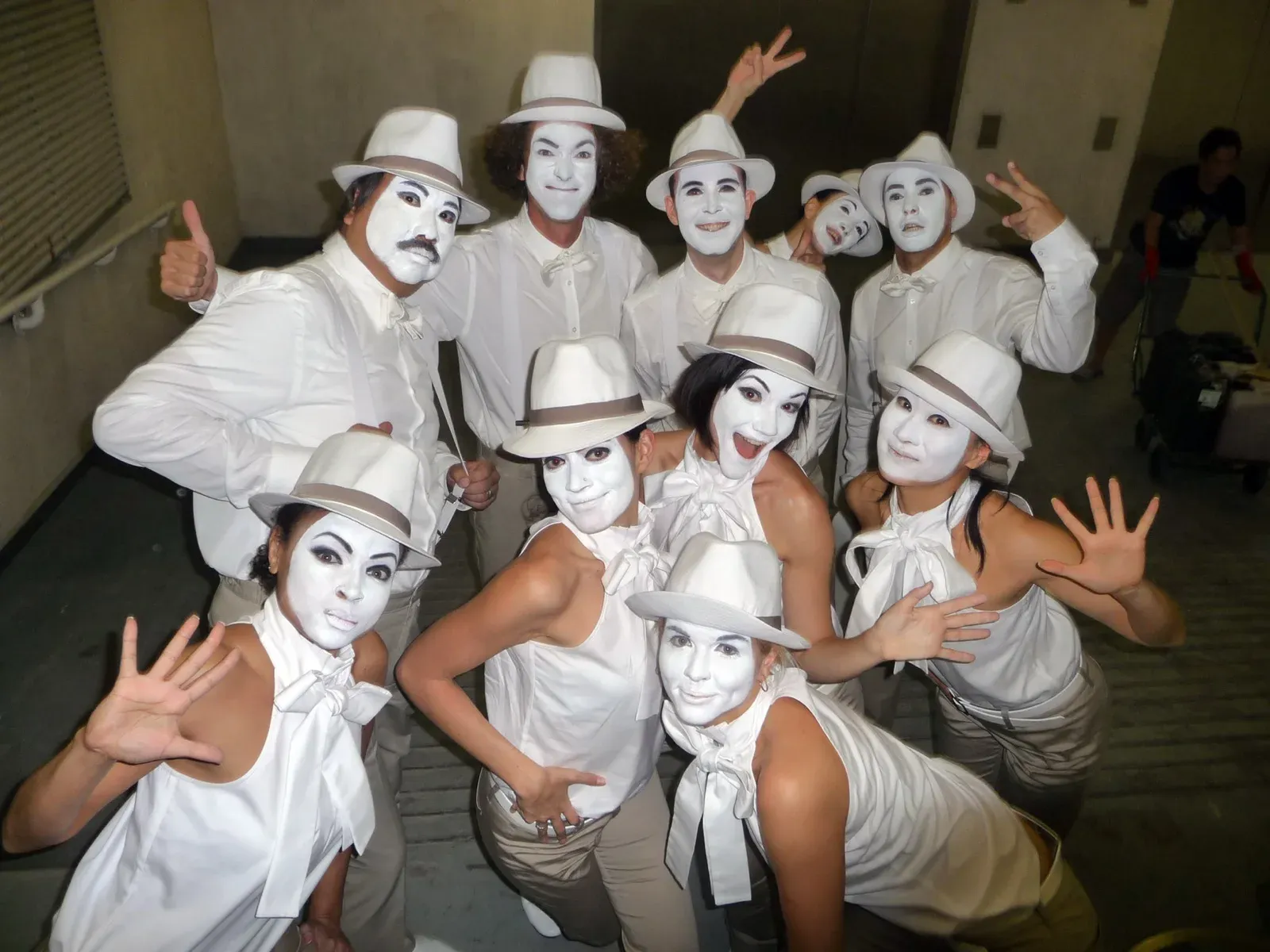 Group of white-face performers in white hats posing together