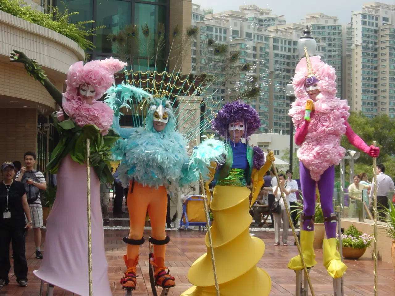 Two stilt walkers at the Park Island grand opening, one in blue and gold and one in red and gold, in front of a Park Island banner