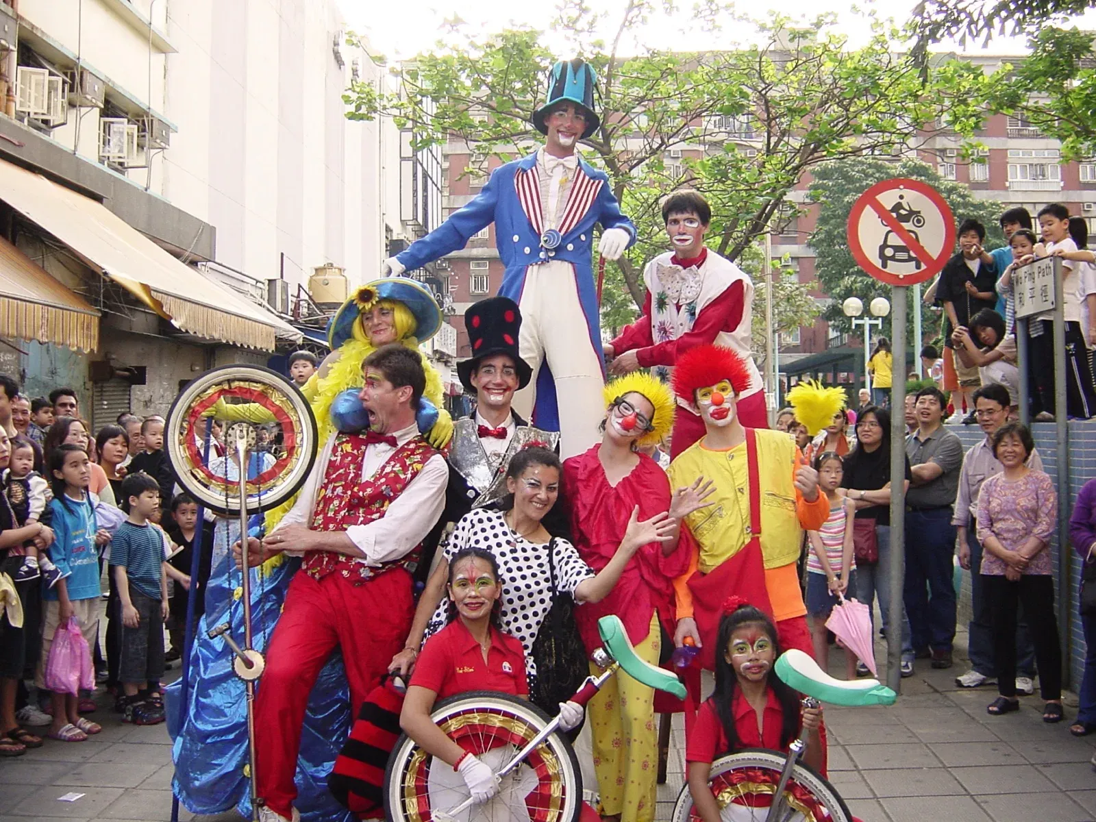 Clowns, stilts walkers and performers with hoops at a Hong Kong street parade