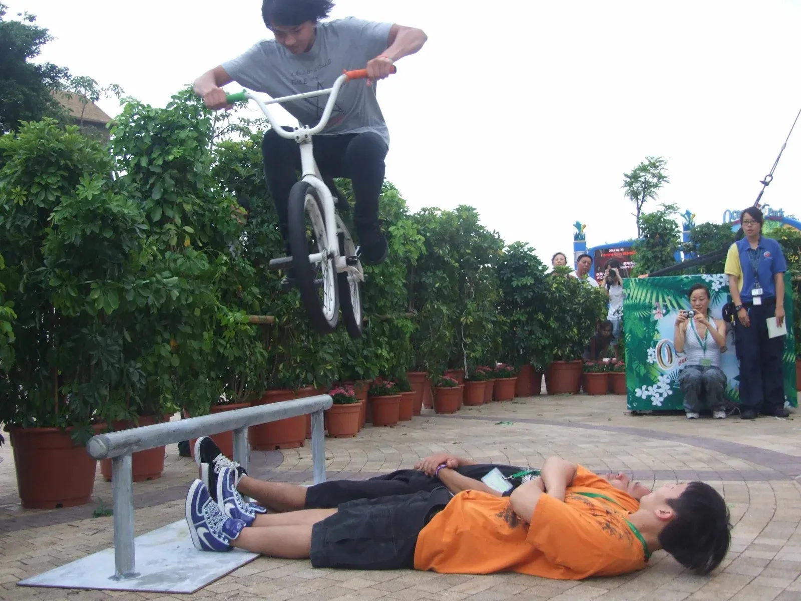 BMX rider jumping over a person lying on the ground at a Hong Kong theme park show