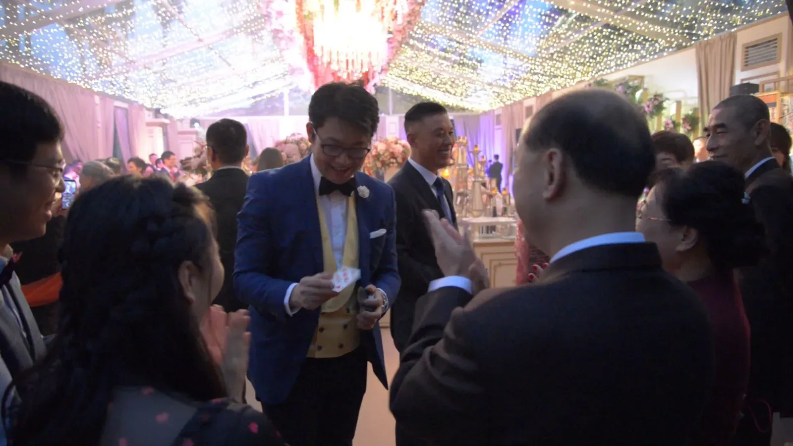 Close-up magician performing card tricks for guests at a wedding banquet in Hong Kong